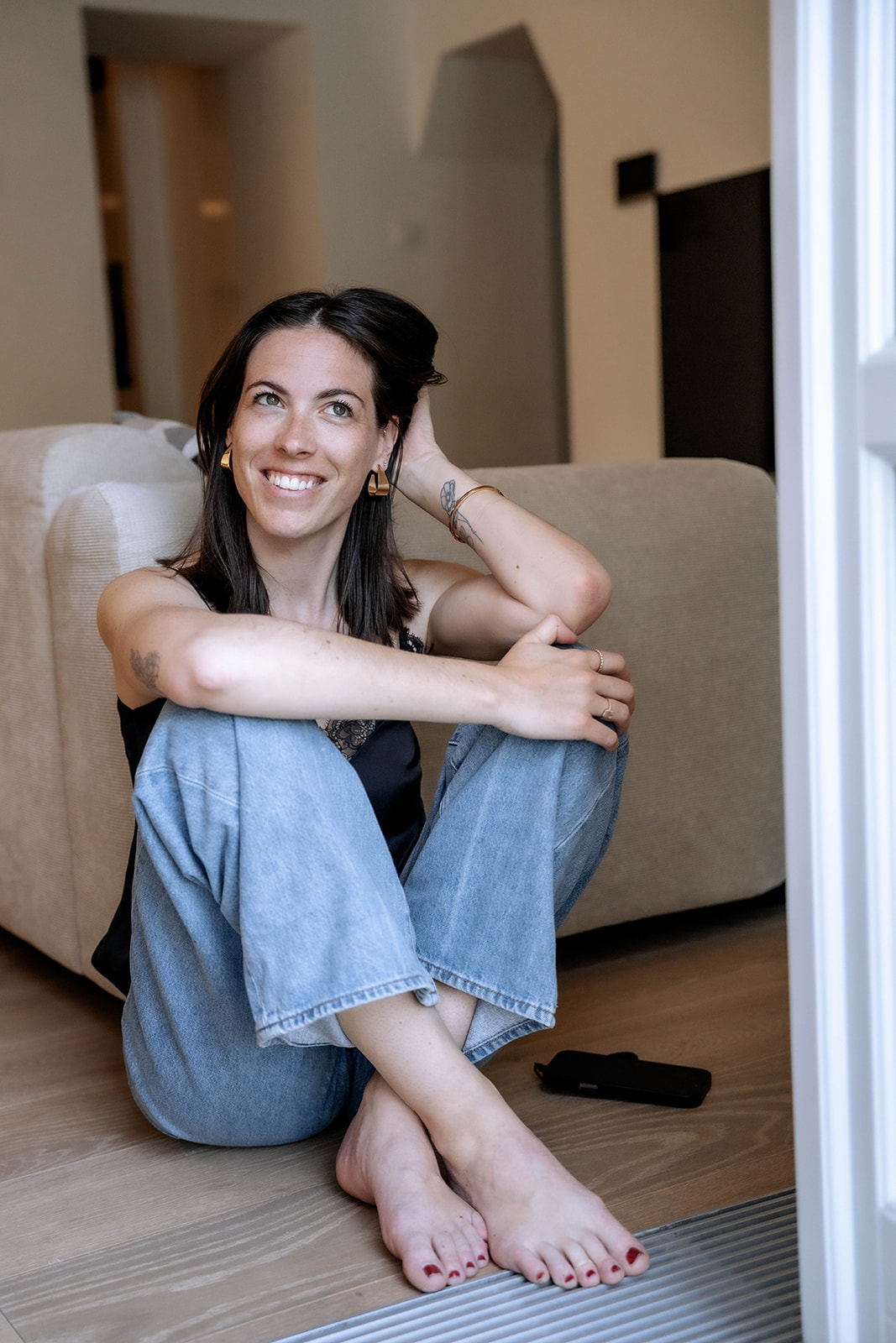 Marie Murer sitzt entspannt auf dem Boden vor dem Sofa