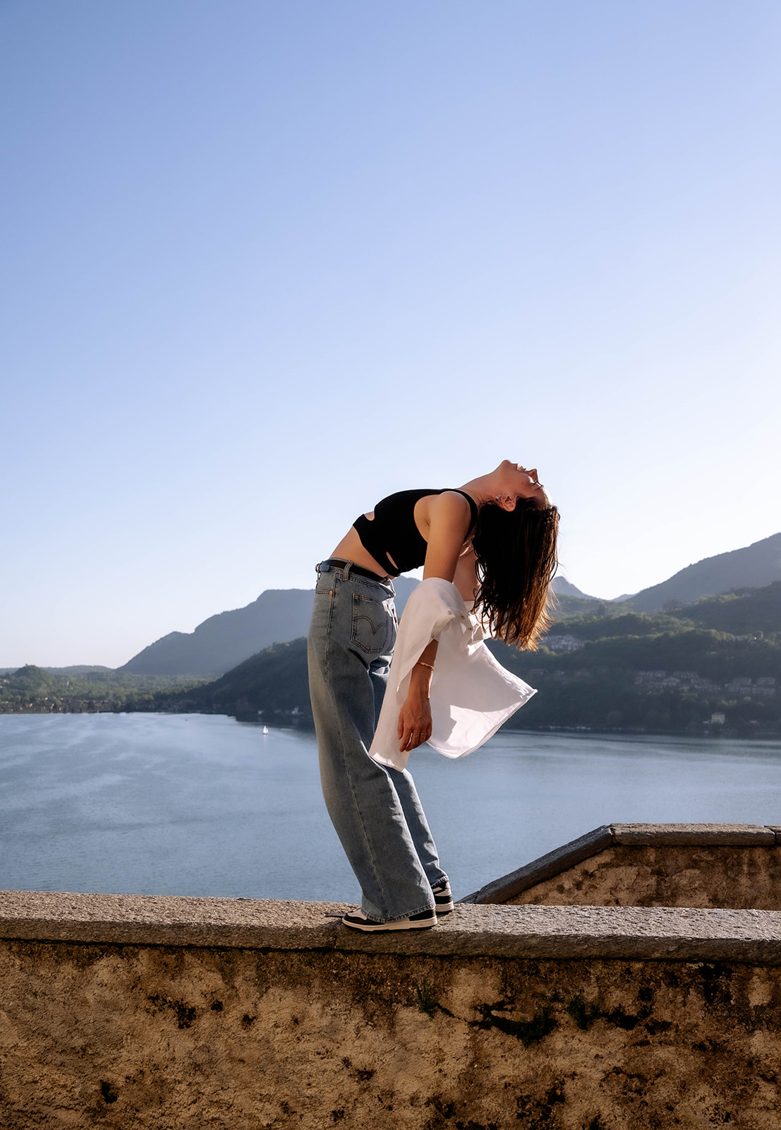 Marie Murer dynamisch auf einer Mauer am See